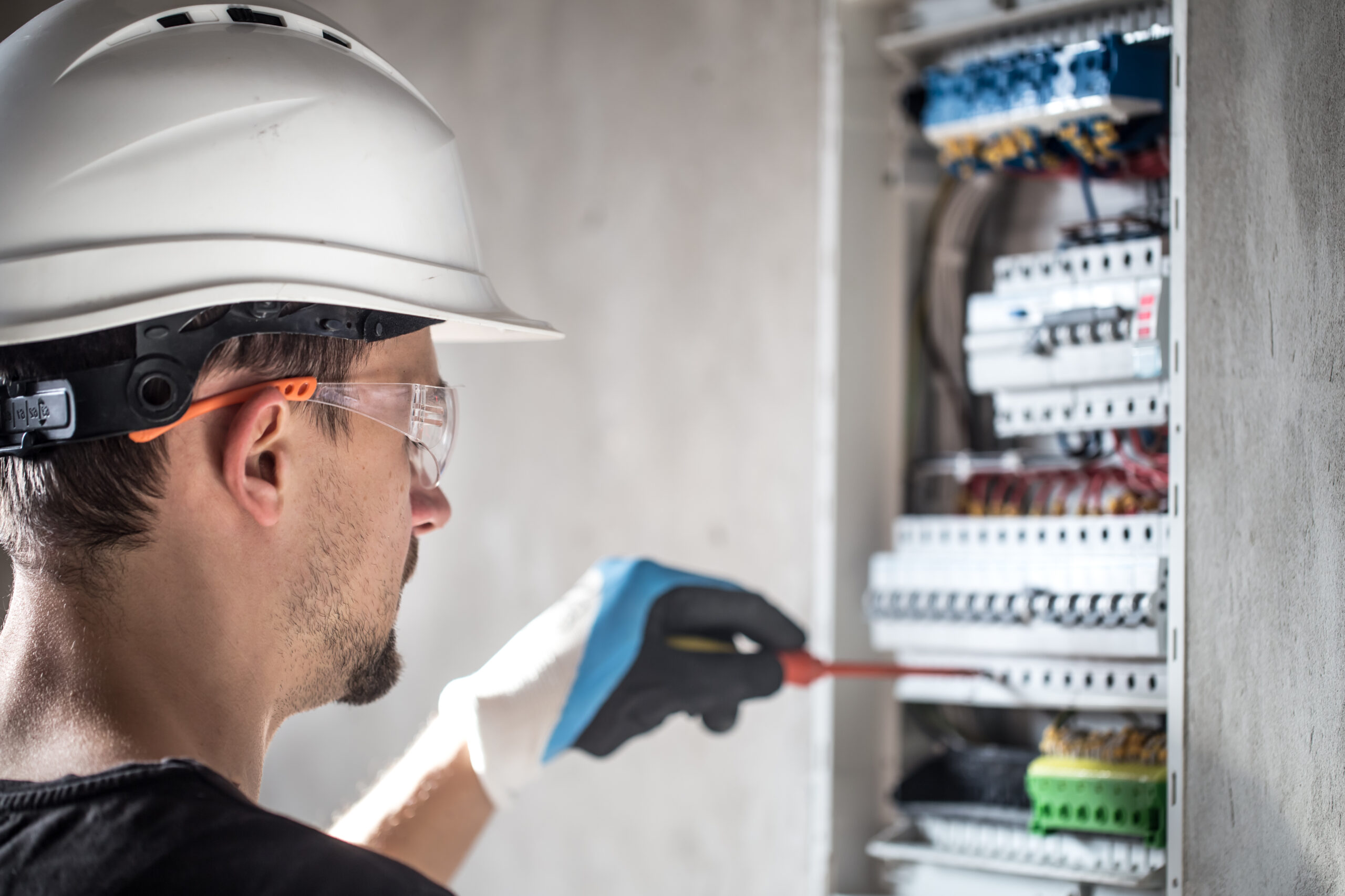 man-an-electrical-technician-working-in-a-switchboard-with-fuses-installation-and-connection-of-electrical-equipment